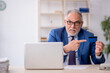 © Elnur - Old male employee holding credit card