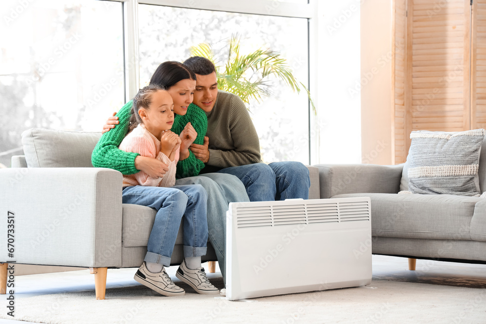 Frozen family warming near radiator at home