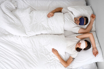 Wall Mural - Young couple sleeping with masks in bedroom, top view