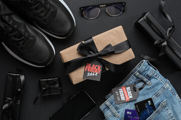 Sticker - Composition with stylish sneakers, mobile phone and gift boxes on dark background, closeup. Black Friday sale