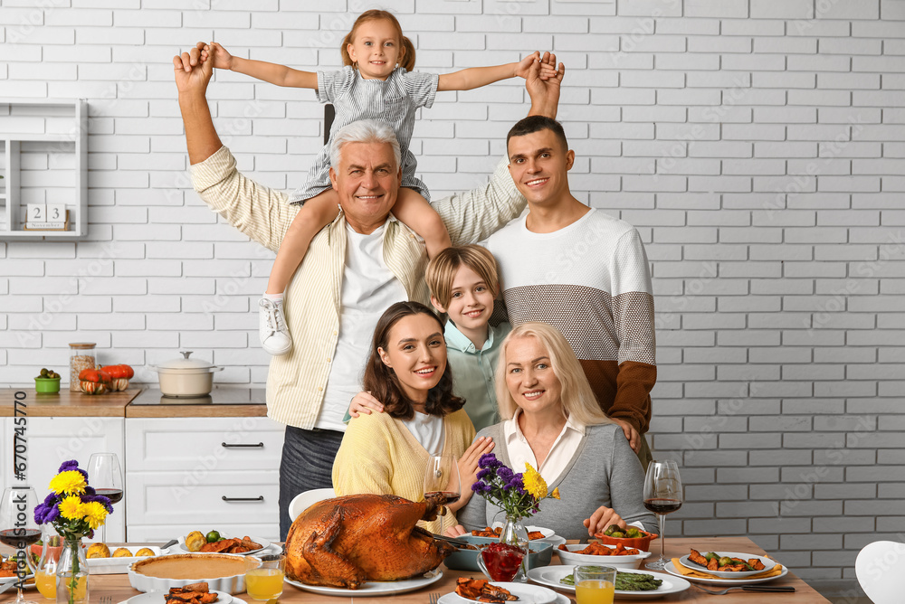 Happy family having dinner at festive table on Thanksgiving Day