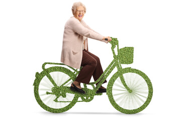 Canvas Print - Elderly lady riding a green bicycle and smiling at camera