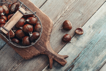 Wall Mural - Edible chestnuts in a metal basket