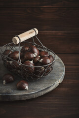 Wall Mural - Edible chestnuts in a metal basket