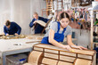 © JackF - Young female carpenter working on making vintage commode in workshop