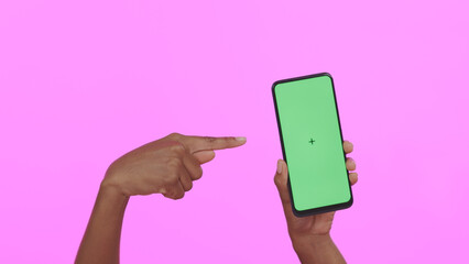 Poster - Hands, pointing at green screen and smartphone, advertising mockup with app and ads on pink background. Tracking marker, person in studio with online information for website and tech marketing