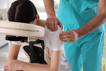 Sticker - Woman receiving massage in modern chair indoors, closeup