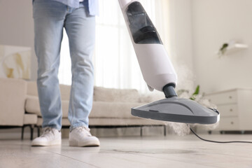 Wall Mural - Man cleaning floor with steam mop at home, closeup