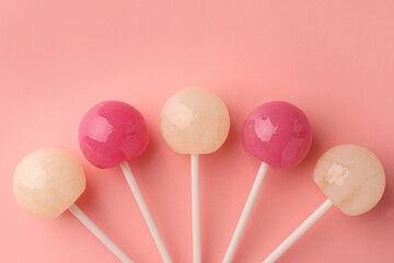 Canvas Print - Tasty lollipops on pink background, flat lay. Space for text