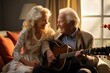 © sirisakboakaew - An elderly man plays guitar for his wife on the sofa in the living room.