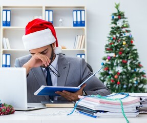 Wall Mural - Young businessman celebrating christmas in the office