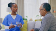 © Charlize D/peopleimages.com - Assisted living, healthcare of medicine with an old man and nurse in a home for medical care or treatment. Help, pills or chronic medication with a black woman volunteer talking to a senior patient