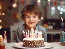 Portrait Of A Boy Preparing To Blow Out Candles On A Birthday Cake. Festive Background.