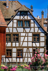 Canvas Print - Ornate traditional half timbered houses with blooming flowers along the canals in the picturesque Petite France district of Strasbourg, Alsace, France