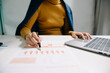 © Nuttapong punna - business documents on office desk with laptop and smart phone and graph business diagram and man working at office
