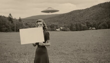 Mysterious Alien Encounter: Woman Holds Warning Sign Under Glowing Ufo Ray