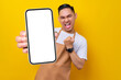 © Bangun Stock Photo - excited young Asian man barista barman employee wearing brown apron work in coffee shop holding mobile phone and showing winner gesture isolated on yellow background. Small business startup concept