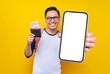 © Bangun Stock Photo - Smiling young Asian student man in casual clothes and glasses backpack holding wallet full of cash money and celebrating winner isolated on yellow background