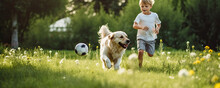 Young Boy Playing Soccer With His Dog On Green Grass.