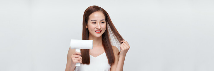 Wall Mural - portrait of a young woman using a dryer on white banner background