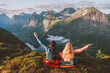 Couple enjoying mountains friends hiking together travel adventure vacations with camping gear, Man and woman in sleeping bags bivouac outdoor family raised arms healthy lifestyle in Norway