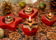Stern-Teelichthalter mit brennenden Teelicht in rot mit Glitzerstaub. Die Kerzen sind zweifarbig mit Glitzer.