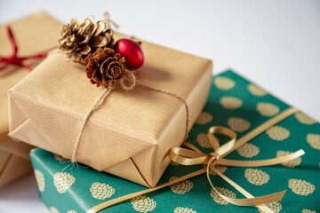 Three Christmas gifts packed in vintage paper and decorations are on a white background.  Packed beautiful gifts close up.