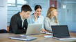 © Bojan - Business coworkers in smart casual wear working in office. Busy businesswoman talking on phone, handsome businessman using laptop and middle aged businesswoman looking away in contemporary workspace.