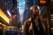 In the midst of the nocturnal cityscape, a black, bald woman stands against the illuminated urban backdrop