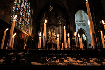 Wall Mural - Virgin Mary in church and burning candles near her.