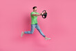 Full body photo of crazy automobile driver wear green t shirt drive fast speed vehicle steering wheel isolated on pink color background