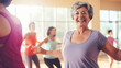 © BlazingDesigns - Senior woman enjoying a joyful dance class, fitness dance zumba class.