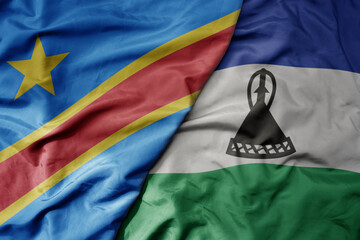 big waving national colorful flag of democratic republic of the congo and national flag of lesotho .