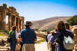 Tourists look at the ruins of an ancient architectural structure of the city