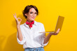 Photo of attractive positive person hold netbook demonstrate okey symbol isolated on yellow color background
