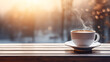 A cup of coffee on an outdoor table with a winter view and a snowy background