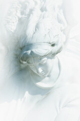 Wall Mural - Vertical image of an ancient stone statue of white angel as symbol of love, faith and hope