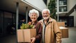 Happy retired couple moving from apartment to new house, packing and unpacking things into boxes for movers