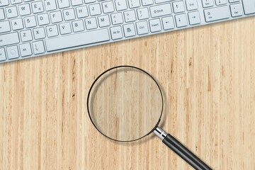 Wall Mural - The magnifying glass and computer keyboard on desk