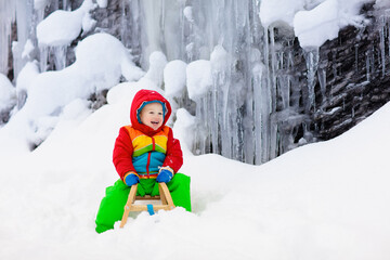 Wall Mural - Boy on sled ride. Child sledding. Kid on sledge