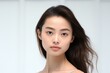 © Restyler - Young charming woman on a light background. Natural makeup. Natural beauty.