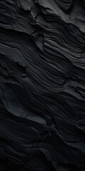 Poster - A detailed close up of a black rock wall. This image can be used in various projects that require textures or backgrounds related to nature, geology, or construction