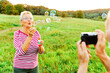 © Lumos sp - woman man outdoor senior couple happy fun retirement together bubble soap camera taking pictures blowing love old nature mature