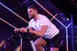 © New Africa - Young man training on exercise bike in fitness club