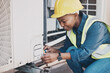 Happy black woman, technician and building installation for air control, construction or vent on roof. African female person, contractor or engineer installing industrial equipment for architecture