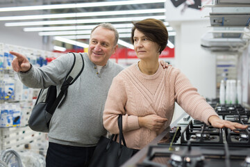 Wall Mural - Mature couple choose a gas stove in an electronics and home appliance store to buy it