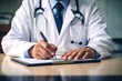 © Supardi - Close up of a male doctor writing on a clipboard