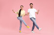 © New Africa - Happy couple dancing together on pink background