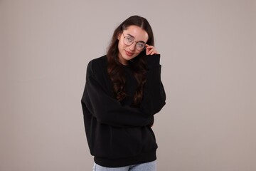 Sticker - Beautiful young woman in stylish warm sweater on grey background