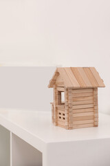 Canvas Print - Wooden house on white shelf indoors, space for text. Educational toy for motor skills development